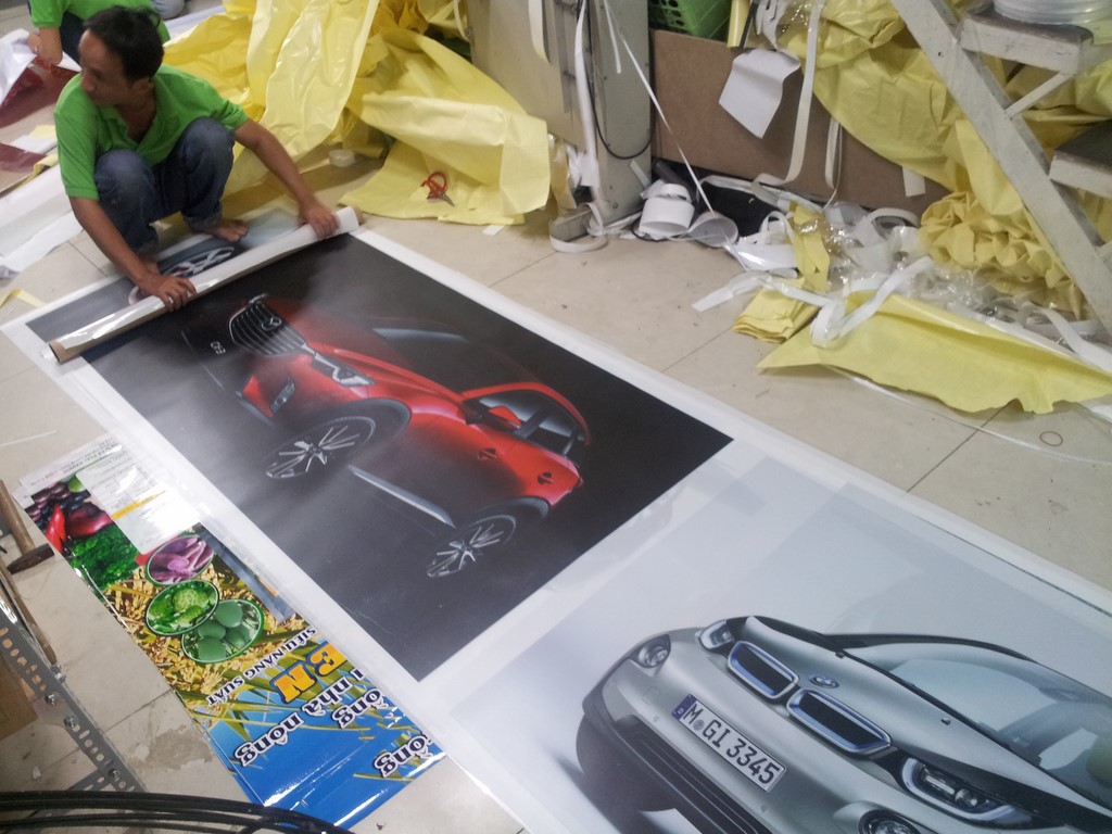 Nhân viên DVQuangCao đang tiến hành gia công thành phẩm in backlit film trang trí showroom xe hơi